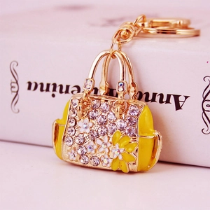 Elegant gold handbag keychain with yellow enamel floral design and sparkling crystals