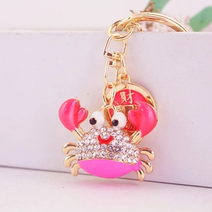 Pink crab keychain with sparkling rhinestones and a golden fortune coin charm