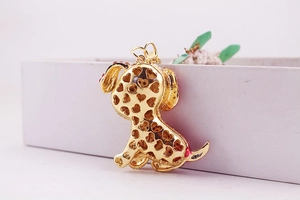 Detail of gold metal puppy keychain showing the unique hollow heart pattern on the back