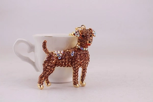 Macro detail of puppy keychain with dark brown rhinestones on golden metal base