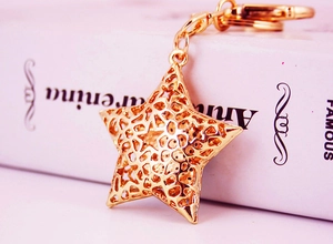 Macro shot of gold star keychain with hollow geometric patterns on a book background