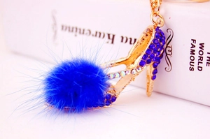 Vue macro du porte-clés à talons hauts avec strass bleu foncé et pompon doux en peluche