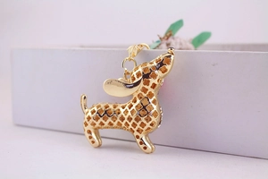 Macro view of gold dachshund keychain with hollow clover pattern and rhinestones