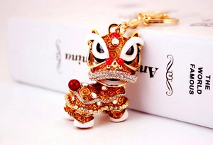 Gros plan du porte-clés lion chinois avec émail rouge et strass brillants décoratifs