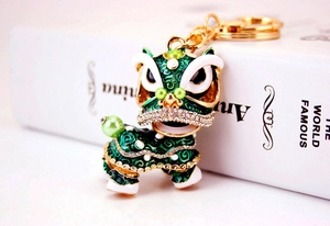 Détail de l'attache porte-clés lion chinois vert orné de strass et finition dorée