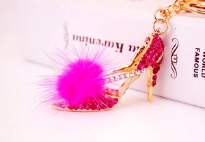 Détail d'un porte-clés escarpin avec pompon en fourrure rose et cristaux sur métal doré