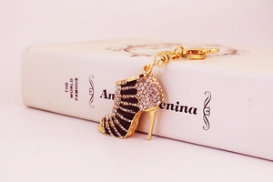 Detalle del llavero de tacón alto dorado con diamantes de imitación y esmalte negro