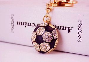 Macro view of soccer ball keychain with sparkling rhinestones and black enamel details