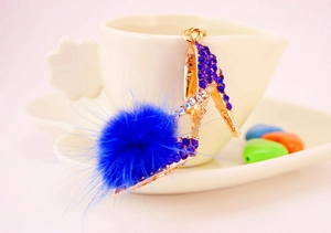 Détail du porte-clés escarpin avec strass bleu roi et ornement pompon en fourrure