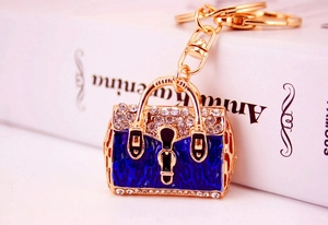 Detail of blue enamel handbag keychain with sparkling rhinestones on golden metal base