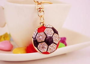 Macro shot of gold-plated soccer keychain with sparkling rhinestones and enamel details