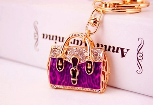 Detail shot of handbag keychain with purple leopard enamel and sparkling rhinestones