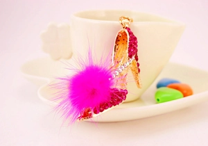 Détail d'un porte-clés escarpin avec strass roses et un pompon en fourrure douce
