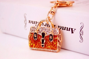 Detailed close-up of a leopard print handbag keychain with rhinestones on a book