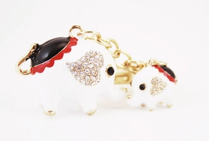 Vue macro de breloques éléphants en émail blanc avec strass brillants et chaînes dorées
