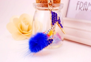 Gros plan détaillé d'un porte-clés à talon haut avec strass bleus et pompon en fourrure
