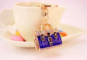 Creative handbag keychain with blue enamel and sparkling rhinestones on a coffee cup