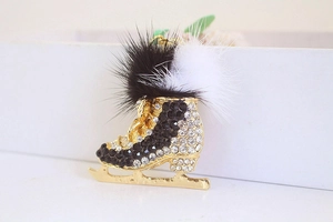 Detailed close-up of a skate keychain with white black rhinestones and soft pom poms