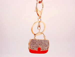 Détail du porte-clés sac à main rouge avec strass blancs étincelants et fermoir doré