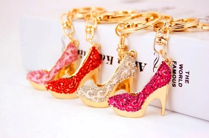 Détail de porte-clés escarpins en cristal en rose, rouge et argent avec base dorée