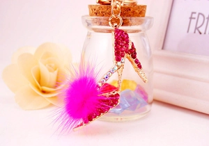 Détail d'un porte-clés escarpin avec strass roses et pompon doux sur monture en métal doré