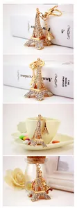Close-up of golden Eiffel Tower keychain with sparkling white crystals on metal lobster clasp