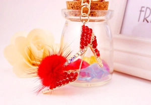 Détail du porte-clés escarpin rouge avec strass brillants et pompon en fourrure pelucheuse