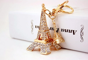 Close-up of golden Eiffel Tower keychain with sparkling rhinestones on white books