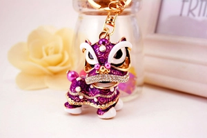 Détails des strass violets et des perles sur le porte-clés chinois lion dansant de luxe