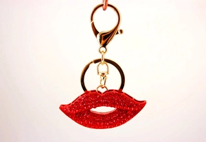 Détail du porte-clés lèvres en strass rouges avec fermoir mousqueton doré brillant