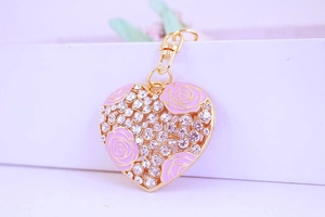 Détail d'un porte-clés cœur avec rose en émail rose et strass en cristal étincelants