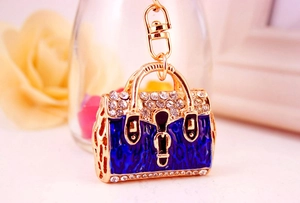 Detail of blue leopard enamel handbag keychain with gold metal and sparkling rhinestones