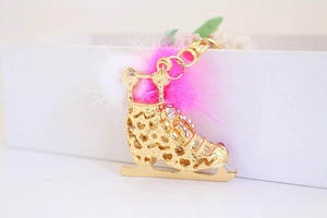 Detail of creative roller skate keychain with pink fur pom pom and sparkly rhinestones
