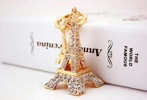 Detail view of a golden Eiffel Tower keychain with sparkling rhinestones and metal ring