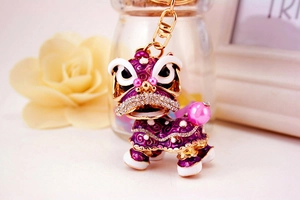 Vue macro du porte-clés lion en émail violet avec des strass et des perles