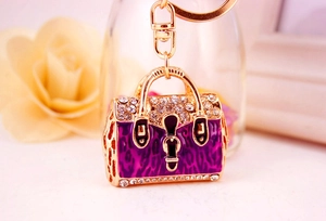 Detail of golden handbag keychain with purple leopard enamel and sparkling rhinestones