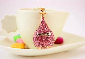 Detailed macro view of a gold perfume bottle keychain encrusted with pink rhinestones