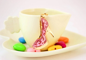 Vue macro d'un porte-clés talon haut doré avec strass roses sur une tasse