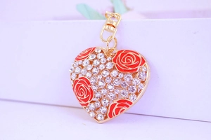 Gros plan du porte-clés en forme de cœur avec roses rouges et strass scintillants