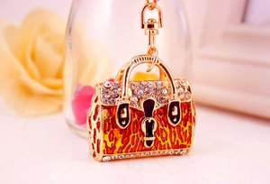 Macro shot of handbag keychain with gold plating, sparkling rhinestones and orange animal print