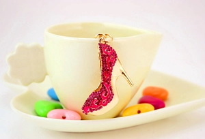 Gros plan détaillé d'un porte-clés escarpin rose en strass suspendu à une tasse en céramique