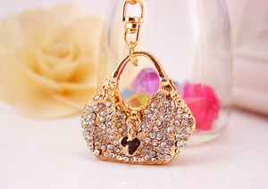 Macro shot of gold handbag keychain with sparkling rhinestones and heart pendant detail