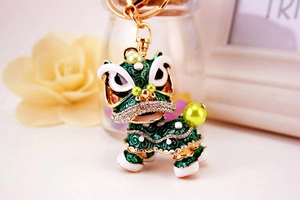 Macro d'un porte-clés lion chinois serti de strass verts avec finition dorée élégante