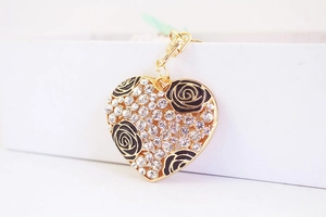 Detailed macro view of heart-shaped pendant with crystal rhinestones and black roses