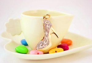 Détail d'un porte-clés escarpin orné de strass brillants accroché à une tasse à café