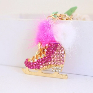 Pink rhinestone ice skate keychain with fluffy pom poms and gold metal hardware