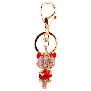 Sparkling gold lucky cat keychain with white rhinestones and a large red crystal pendant
