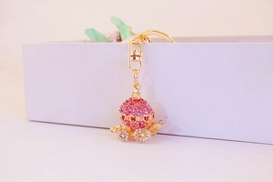 Detail view of pink rhinestone pumpkin carriage keychain with gold heart cutouts