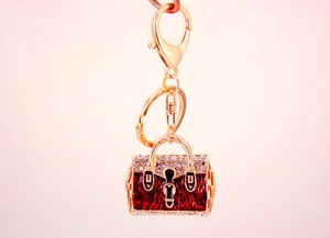 Detail of red leopard print handbag keychain with rhinestones on a gold metal link