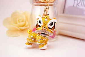 Détail d'un porte-clés lion chinois avec placage or et strass blancs étincelants